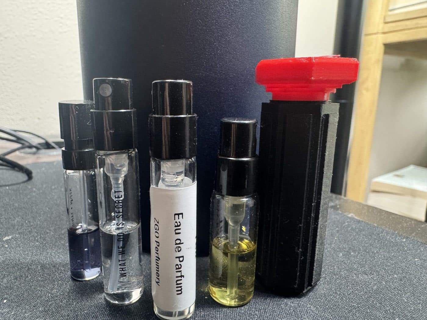 The case beside the decant vials it was designed around, the size envelope that set every internal dimension.