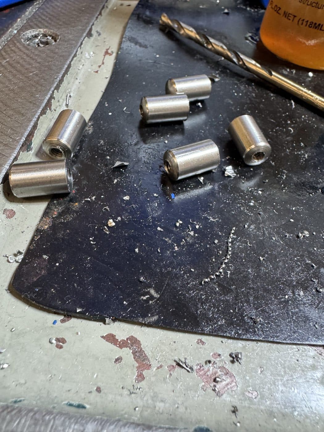 A run of turned and bored steel bushings, drilled through and faced to length.
