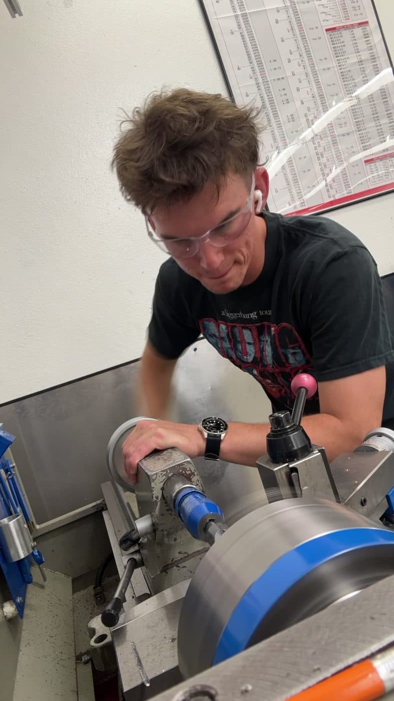 Advancing the carriage on a facing pass at the manual lathe.