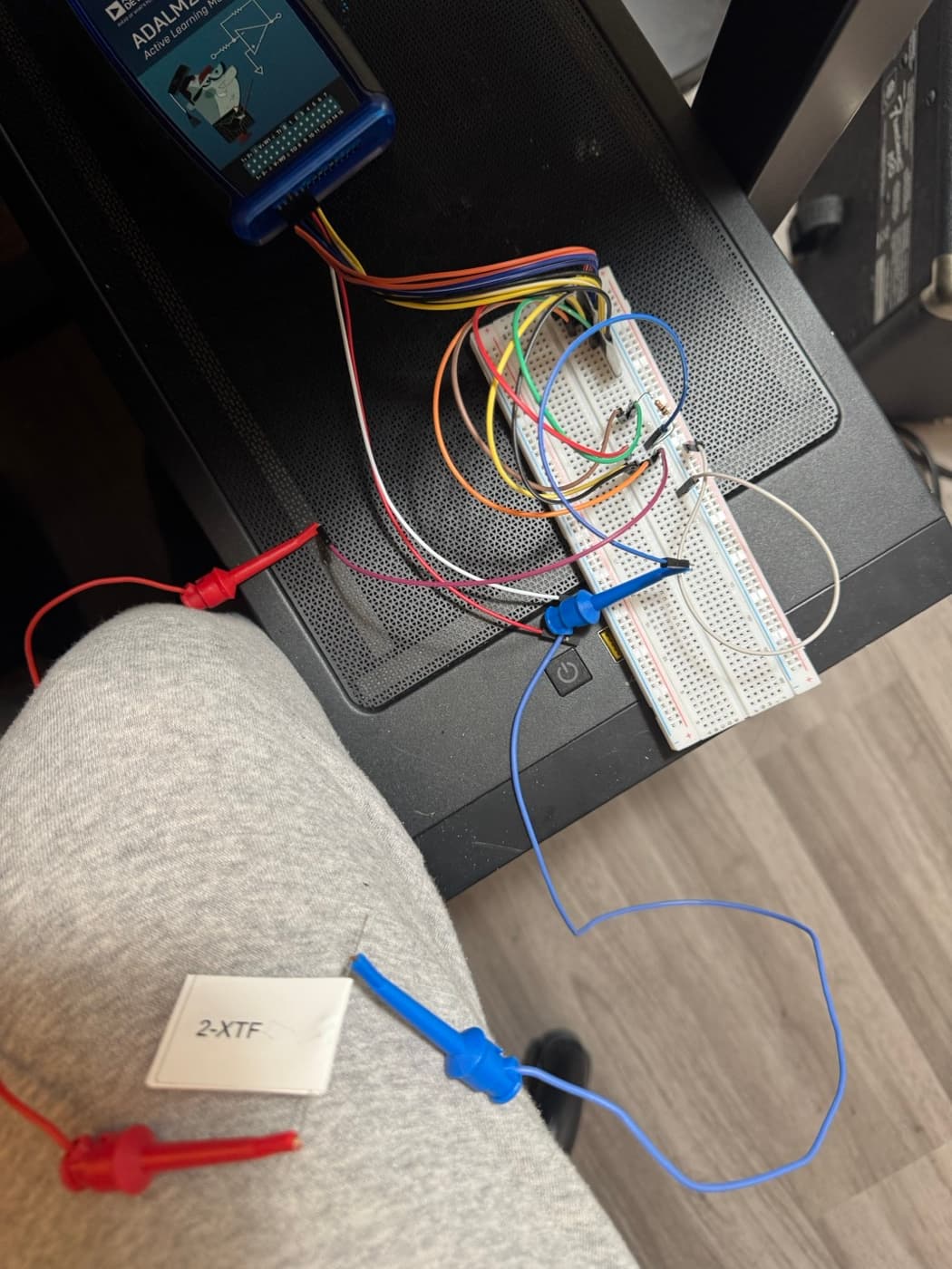 Circuits lab bench with an ADALM2000 active learning module wired to a breadboard.